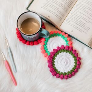crocheted coasters, mug, and book